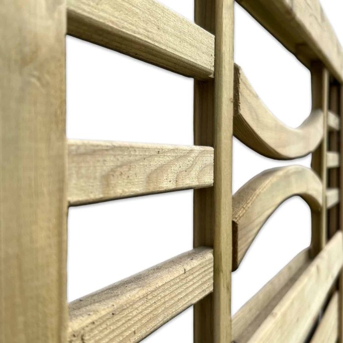 Nærbillede af en Havelåge m/espalier trykimpr. med lodrette og vandrette lameller. Hegnets tekstur og korn er tydeligt synlige, hvilket giver det et rustikt udseende. Nogle af de vandrette lameller er let buede. Baggrunden er hvid.