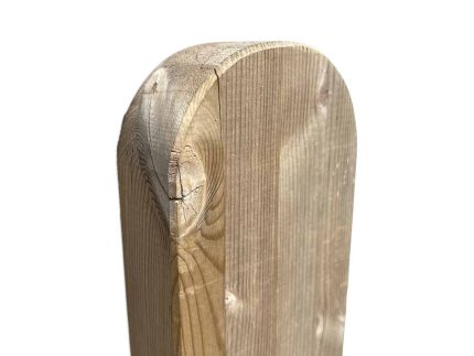 Nærbillede af den øverste del af en hegnspæl med en afrundet kant, almindeligvis brugt til fremstilling af en Havelåge ramme trymimpr. Træets årer og tekstur er tydeligt synlige, sammen med nogle naturlige knaster i træet. Baggrunden er helt hvid, hvilket gør indlægget til billedets eneste fokus.