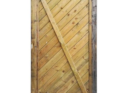 En høj, rektangulær Havelåge trykimpr trædør med diagonalt plankedesign og kant. Træet fremstår forvitret med en blanding af lyse og mørkere toner, der viser naturlige årer og knaster. Dørrammens kanter er afrundede, der ligner en rustik port.