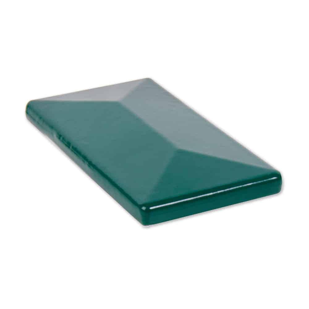 En blank, grøn, rektangulær keramisk flise, der måler 60x40 mm, ses fra en vinkel og afslører dens hævede, skrå overflade og glatte tekstur. Flisen har en let reflekterende finish og er sat mod en almindelig hvid baggrund.