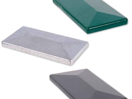 Tre forskelligt farvede, rektangulære Stolpehatte-fliser med skrå overflader er arrangeret separat. De blanke aluminiumsfliser fås i dyb grøn, metallisk sølv og mørkegrå. Hver flise måler 60x40 mm og passer perfekt til Stolpehatte-design.