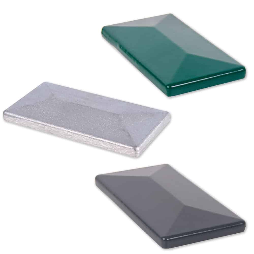 Tre forskelligt farvede, rektangulære Stolpehatte-fliser med skrå overflader er arrangeret separat. De blanke aluminiumsfliser fås i dyb grøn, metallisk sølv og mørkegrå. Hver flise måler 60x40 mm og passer perfekt til Stolpehatte-design.