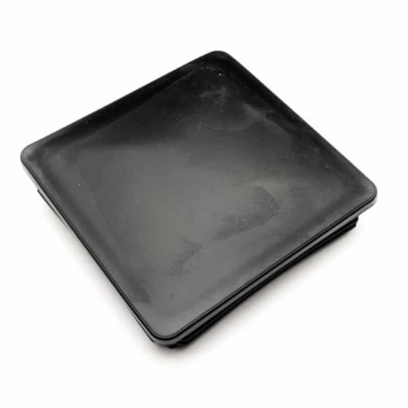 En firkantet sort plade med let hævede kanter, placeret på en hvid baggrund, har en glat, blank finish og ser ud til at være tom. Det slanke design minder om moderne arkitektoniske elementer som Plastik stolpehat til stålstolpe 100x100mm.