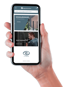 En hånd holder en smartphone, der viser en hjemmeside. Hjemmesiden indeholder sektioner med titlen "Hegnsøsolutionger", "Montageservice" og "e-marked" med billeder af hegn, en mand i arbejdstøj og et "e"-symbol. Logoet er øverst og fremhæver dets ekspertise inden for galvaniseret hegn og låger.