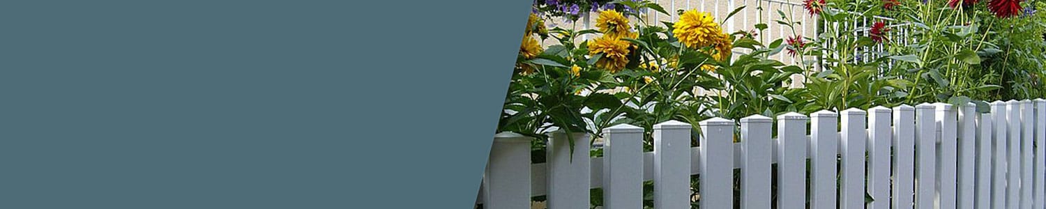Et hvidt stakit kanter en have fyldt med farvestrålende blomster, inklusive gule og røde blomster. Baggrunden viser en del af en husmur. På venstre side af billedet ligner en stor, solid blå trekant et kunstnerisk banner.