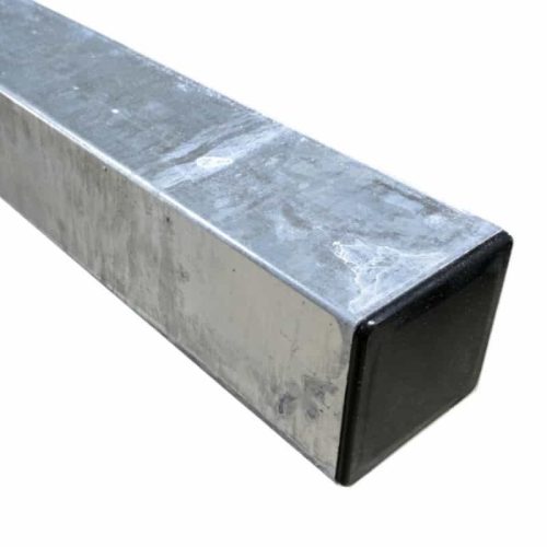 Nærbillede af et firkantet metalrør, stålstolpe varmgalv. 100x100x2600mm, med en skinnende, reflekterende overflade. Røret er hult og har en sort plastikhætte i den ene ende. Metaloverfladen fremstår let slidt med enkelte synlige ridser og mærker.