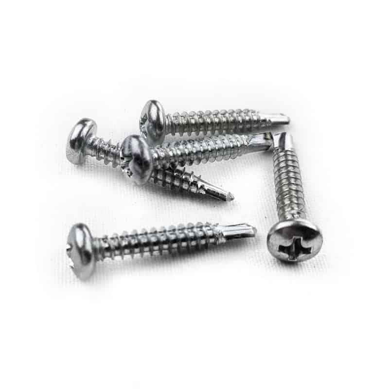 Et nærbillede af seks elforzinket selvskærende skruer med flade, slidsede hoveder og spidse ender liggende på en hvid overflade.