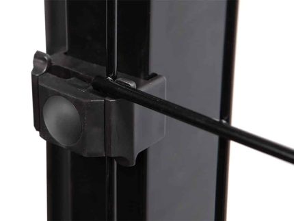 Et nærbillede viser en del af en metallisk sort ramme med en klemme, der fastgør en tynd sort stang til den. Klemmen, der ligner Punkt Beslag Sæt til 60x40 stolper/panelhegn, har en knap eller knop på siden. Billedet fokuserer på forbindelsespunktet og fremhæver fastgørelsesmekanismen.