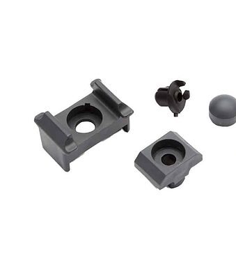 Punkt Beslag Sæt til 60x40 stolper/panelhegn er et sæt grå plastik- og metalkomponenter, inklusive to monteringsbeslag, en lille cirkulær hætte, et lille sort stykke med fire ben og en stjerneskrue.