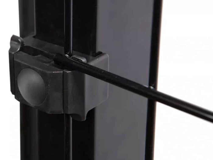 Nærbillede af Metal Stolpe "BLACKY" 60x40mm, med en sort låsemekanisme med en vandret metalstang, der passerer igennem den. Låsen fastgøres til den lodrette, pulverlakerede sorte metalstolpe, hvilket viser dens robuste og enkle design. Baggrunden er sløret, hvilket fremhæver låsens detaljer.