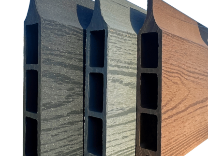 En række af tre Type 1-kompositterrassebrædder fra Komposit Hegn-kollektionen, med hule centre og vist lodret for at vise deres forskellige farver - mørkegrå, lysegrå og brun - fra venstre mod højre. Hvert bræt har en træstruktur på overfladen og er sat mod en almindelig grøn baggrund, hvilket gør dem ideelle til dit komposit hegn-projekt med galvaniserede stålstolper og U-kanaler.