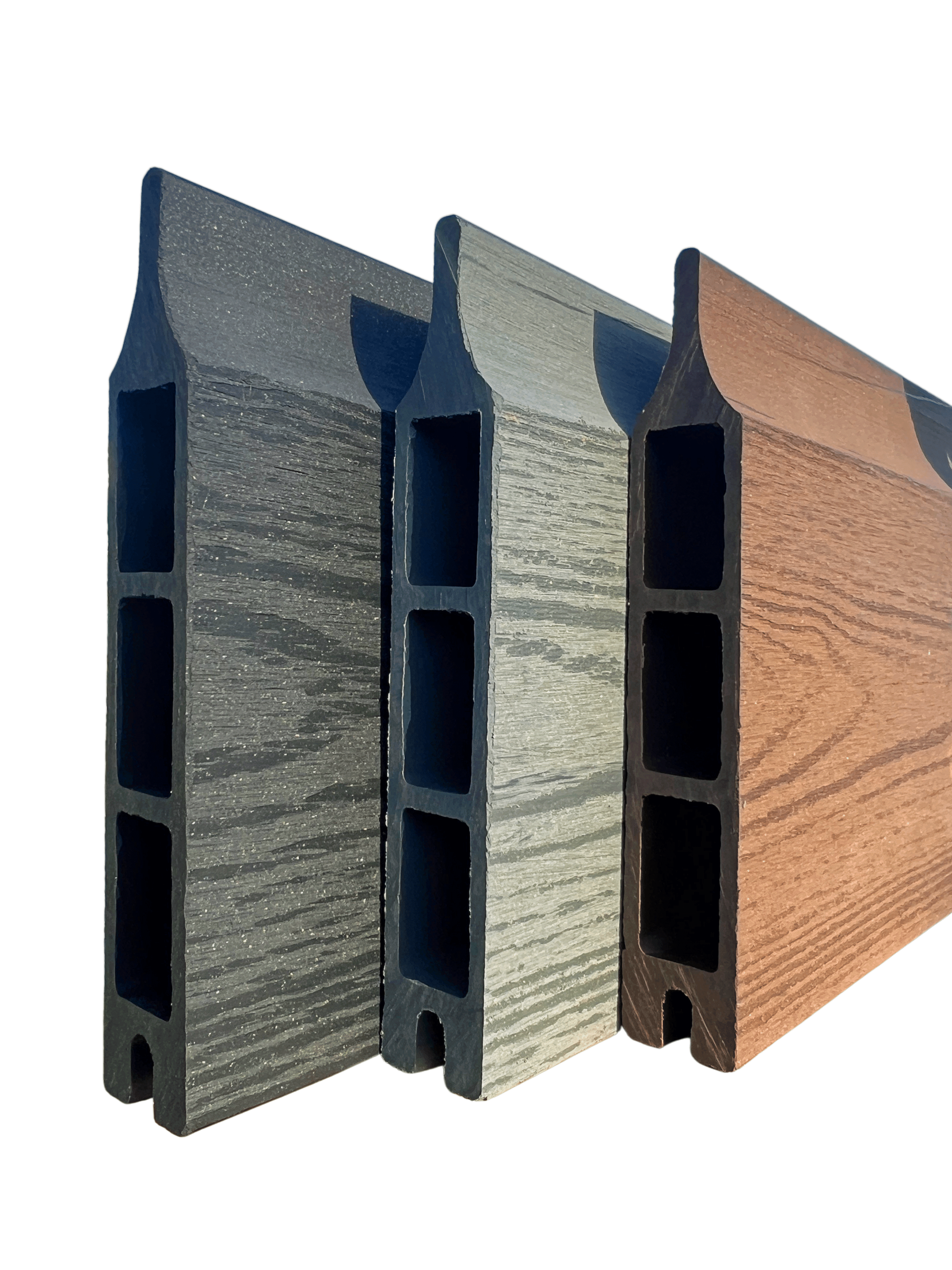 En række af tre Type 1-kompositterrassebrædder fra Komposit Hegn-kollektionen, med hule centre og vist lodret for at vise deres forskellige farver - mørkegrå, lysegrå og brun - fra venstre mod højre. Hvert bræt har en træstruktur på overfladen og er sat mod en almindelig grøn baggrund, hvilket gør dem ideelle til dit komposit hegn-projekt med galvaniserede stålstolper og U-kanaler.