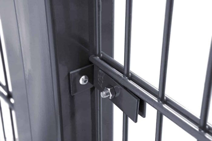 Nærbillede af en sort metal gate låsemekanisme. Låsen er sikret med en bolt, der går gennem en plade fastgjort til Vinkelbeslag til midt stolpe - Låge ramme. Designet er moderne med lodrette stænger og et rent, industrielt look.