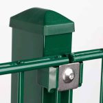 Nærbillede af en grøn metal hegnspæl med en hætte og en vandret stang fastgjort ved hjælp af en Holdeplade med hul - Rustfrit stål beslag og bolt. Baggrunden er almindelig hvid, hvilket fremhæver posten og dens forbindelseskomponenter.