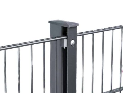 Et nærbillede af et sort metalhegn med lodrette stænger forbundet til en hegnspæl. Stolpen har en firkantet hætte på toppen og har Punkt Beslag 60x40 stolper/panelhegn - en bolt eller skrue på siden til at fastgøre hegnspanelerne. Baggrunden er hvid.