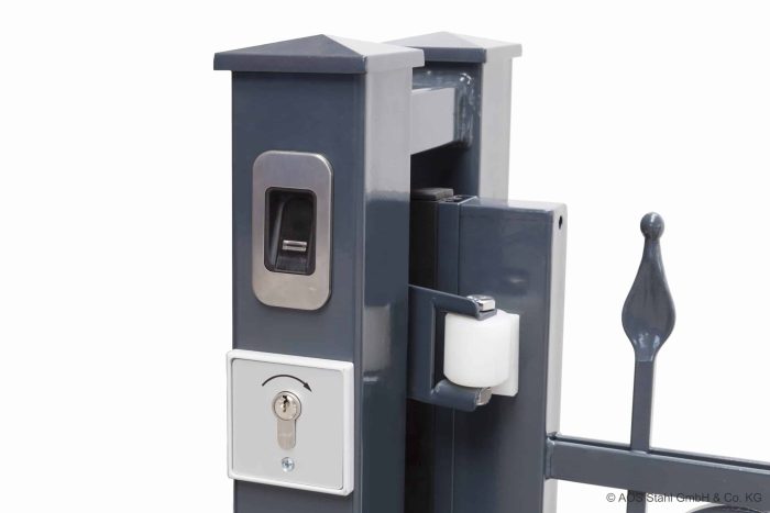 En 8/6/8 MM grå metalportstolpe med fingeraftryksscanner, nøglelås og rullemekanisme. Billedet viser Skydeport "V-Star EXTREME" moderne låsesystem med 2D Panelfyld, med et slankt design og holdbare materialer. Den almindelige hvide baggrund understreger portens detaljer.
