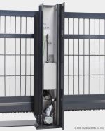 Et nærbillede af en automatisk portsystemkomponent, der viser den indvendige mekanisme anbragt i et lodret metalhus. Huset, integreret i et Skydeport "V-Star EXTREME" 2D Panelfyldt 8/6/8 MM metalhegn med lodrette og vandrette stænger, afslører den indviklede mekanisme inklusive ledninger og en motorkomponent.