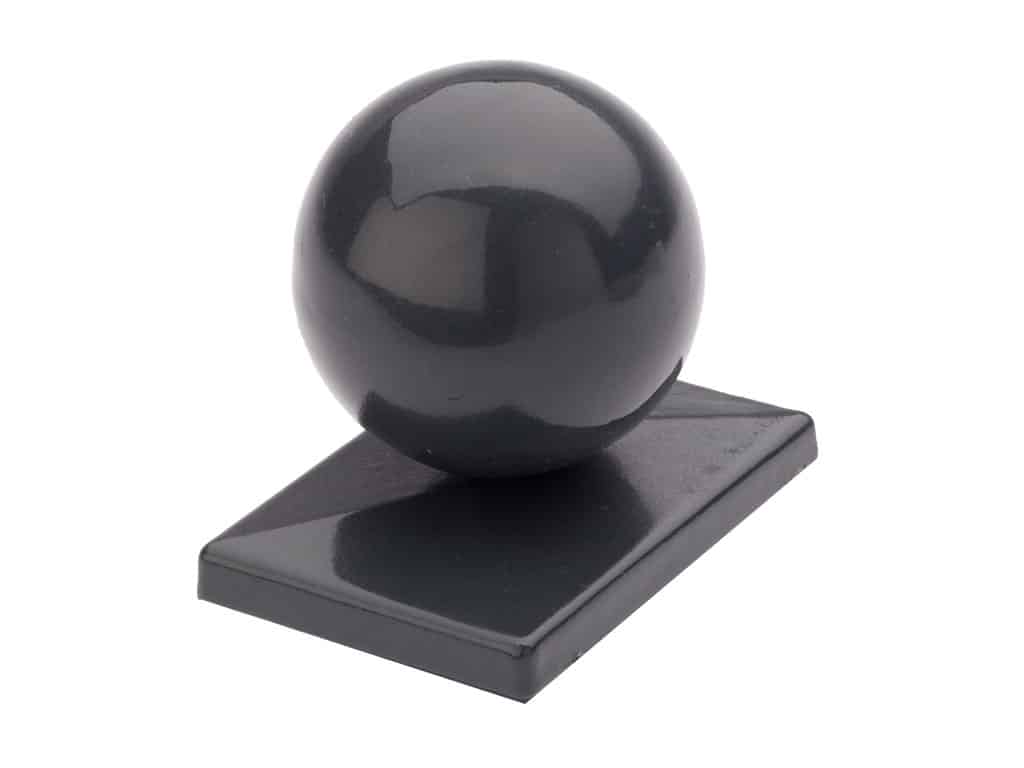 En sort kugle sidder oven på en rektangulær sort base. Basen er let vinklet, og både kuglen og basen har en blank antrazit-finish, der reflekterer lys. Det overordnede design er slankt og minimalistisk.
