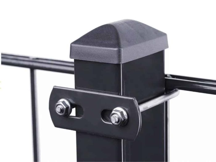Nærbillede af en sort metal hegnspæl med en sort kasket på toppen. Stolpen har en vandret metalstang fastgjort med U-Beslag Sæt 60x40mm, fastgjort med to bolte. Baggrunden er almindelig hvid.