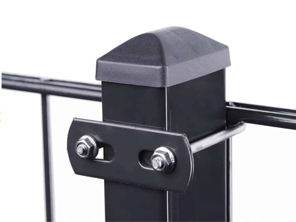 Nærbillede af en sort metal hegnspæl med en sort kasket på toppen. Stolpen har en vandret metalstang fastgjort med U-Beslag Sæt 60x40mm, fastgjort med to bolte. Baggrunden er almindelig hvid.