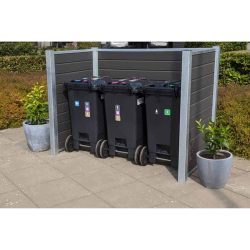 Et sæt med tre sorte skraldespande placeret i en skraldespandsskjul med stålstolper udendørs. Hver beholder har forskellige farvede låg og etiketter til genbrugskategorier. På hver side af børstet sorteringsspande står store potteplanter. Området er belagt med grå fliser og omgivet af grønt.
