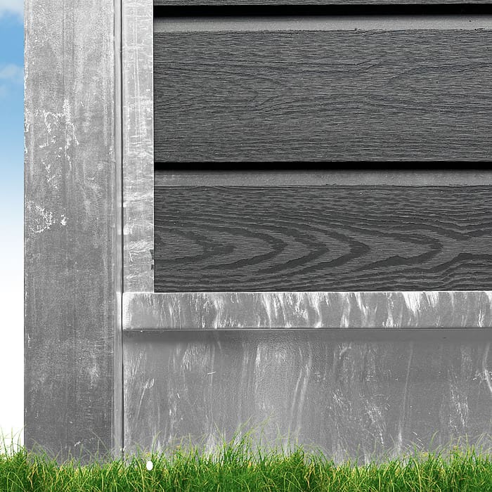 Et nærbillede af den nederste del af en bygning med mørkegrå vandret sidespor. Fundamentet ser ud til at være udført i forvitret Bundplade Galvaniseret Stål - 1815x175x35/2mm. Grønt græs er synligt ved bunden, med en blå himmel i baggrunden.