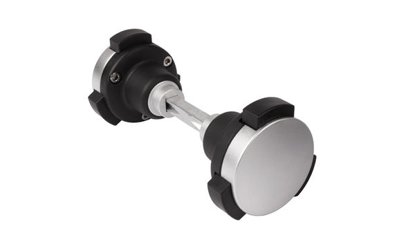 En sølv og sort dobbelt-ende dørprop med et slankt, cylindrisk design. Den centrale metalliske stang forbinder to gummierede propper i hver ende, designet til at absorbere stød. Ideel til moderne rum, den komplementerer KIDLOC - Børnesikret Låsehåndtag til Institutioner med sit minimalistiske udseende.