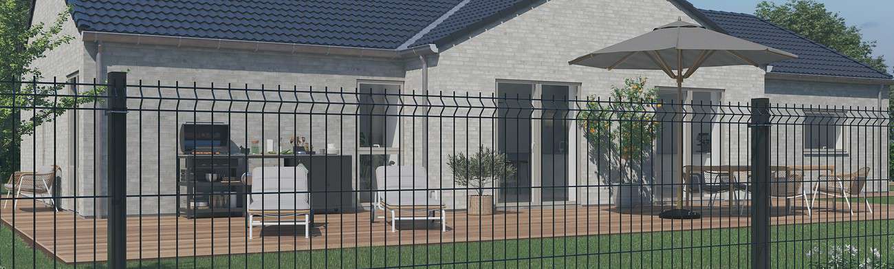 Et moderne hus med blåt tag, store vinduer og træterrasse. Dækket har liggestole, et spisebord med paraply og potteplanter. Huset er omgivet af et sort panel_hegn hegn, og haven har græs og træer.