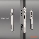 Et billede af en Locinox 3020-HYB låsemekanisme til Metallåge 2D Panelfyld 6/5/6mm Sort Ral 9005 Komplet har tre komponenter: frontplade, låsekrop og bagplade med nøglehulsudskæringer. Mærkets logo er tydeligt vist i nederste højre hjørne.