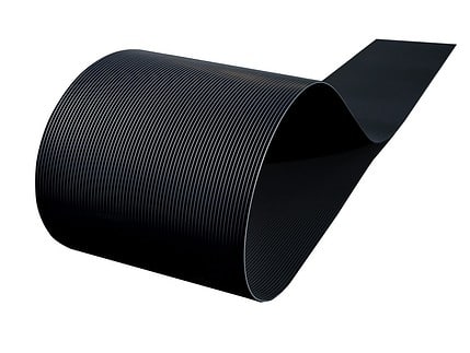 Et nærbillede af en sort POLYFIX Afskærmning rulle 26 m SORT RAL 9005 - Indfletning af Panelhegn, der viser dens fleksible og parallelle linjer, der danner en glat kurve mod en hvid baggrund. Kablets tekstur og ensartede linjer er fremtrædende i billedet, der ligner en slank hegnsstrimler.