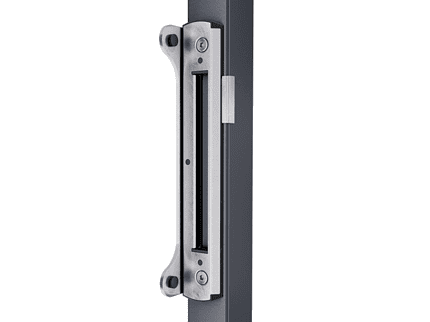 Nærbillede af en Anslag til låger/porte - Rustfrit Stål Overflademonteret fastgjort til kanten af en mørkfarvet dørkarm. Stødpladen har en rektangulær åbning, som låsebolten kan glide ind i og er fastgjort med skruer.