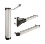 Kompakt Hydraulisk Portlukker "LION" fra Locinox er en sølvfarvet enhed med sort knop og håndtag, vist med stående og adskilte komponenter. Dens cylindriske hoveddel har to flade metalarme, der ender i slanke sorte plastik-fremhævninger.