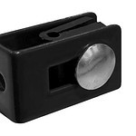 En lille sort rektangulær plastikkomponent med afrundede kanter, med en stor metallisk knap i midten. Den har også et lille hul på den ene side og en synlig spalte langs toppen, svarende til dem, der findes på vægbeslag. Baggrunden er almindelig hvid. Denne genstand er identificeret som Mur/væg Beslag 60x40mm til Panelhegn Sort RAL 9005 (Designserie).