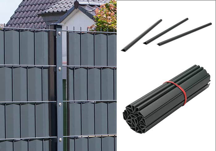 Til venstre ses et metalhegn med lodrette lameller, mens højre side har tre individuelle lameller og et bundt Klemmeskinner Sort PVC til Afskærmningsruller 1 stk. bundet sammen med et rødt bånd. Baggrunden omfatter et delvist billede af et hus med tegltag.