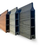 Et nærbillede af tre sammensatte brædder (kompositbræt) i forskellige farver: brun, sort/antracit, grå. Brædderne er vist i en vinkel, hvilket fremhæver deres rillede og hule design. Træets struktur er synlig på hver bræts overflade.