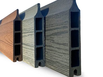 Et nærbillede af tre sammensatte brædder (kompositbræt) i forskellige farver: brun, sort/antracit, grå. Brædderne er vist i en vinkel, hvilket fremhæver deres rillede og hule design. Træets struktur er synlig på hver bræts overflade.