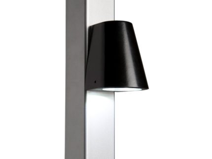 Vi præsenterer Design LED Belysning til Hegn og Porte - Locinox TRICONE, en slank og moderne vægmonteret lampe med en sort konisk skærm fastgjort til en lodret, metallisk overflade. Med LED-belysning leder dette lys belysningen nedad, perfekt til accentbelysning.