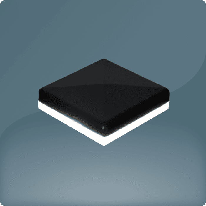 Et firkantet, sort, blankt objekt med skrå kanter, der ligner en flise eller knap, er centreret på en blød gradientbaggrund, der går fra mørk til lysegrå. Dens hvide base forstærker den svævende illusion, hvilket subtilt antyder en LED-Lys-glød.