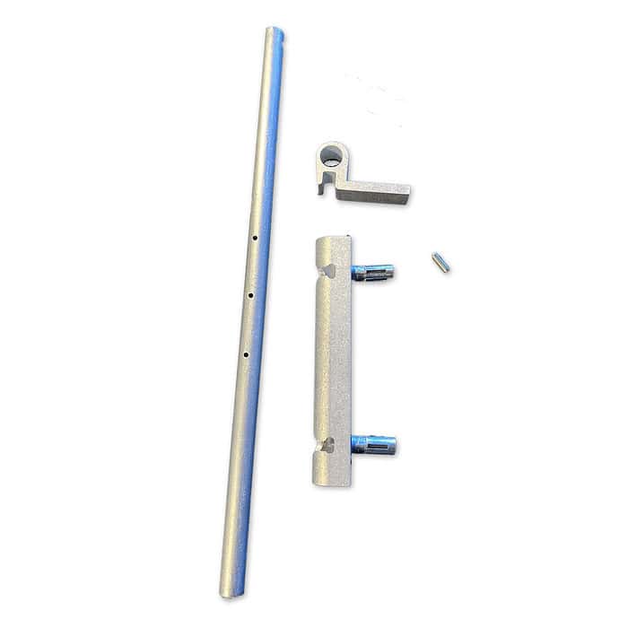 Billede af fire metalliske dele arrangeret på en hvid baggrund. Fra venstre mod højre: en lang perforeret cylindrisk stang, en robust portbolt (Locinox Varmgalvaniseret Skudrigle), et fladt beslag med to cylindriske forlængelser og en lille cylindrisk stift. Delene ser ud til at være komponenter i en mekanisk samling.