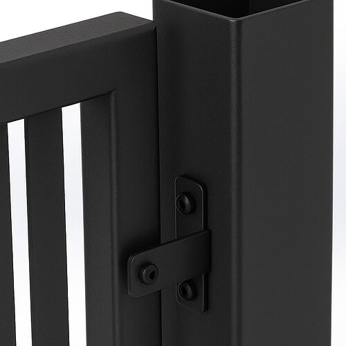 Nærbillede af et sort metalhængsel på en lodret stolpe, der viser Stål Hegn - Jalousi/Palisade | Pulverlakeret ramme med lodrette lameller mod en almindelig hvid baggrund.