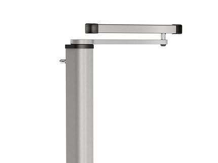 Set fra siden af en metallisk, cylindrisk genstand med et hængsel og en forlænget flad arm på toppen, med sorte accenter i enderne. Denne moderne, industrielle komponent ligner en del af en motoriseret portlukker og antyder dens rolle i et automatiseret port- eller monteringssystem.