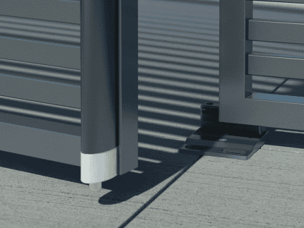 Nærbillede af en moderne metalport med vandrette lameller med Locinox Bundstop til dobbeltlåger – justerbart og overflademonteret (RAL 9005). Det justerbare hængsel og den overflademonterede base er synlige, da porten står let åben på beton.