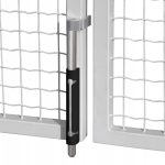 Nærbillede af en skudrigel, der holder to dobbeltlåger af hvidt trådnet sammen. Den cylindriske lås med en slags pulverlakeret RAL 9005-belægning passer ind i et metalbeslag på den ene port.