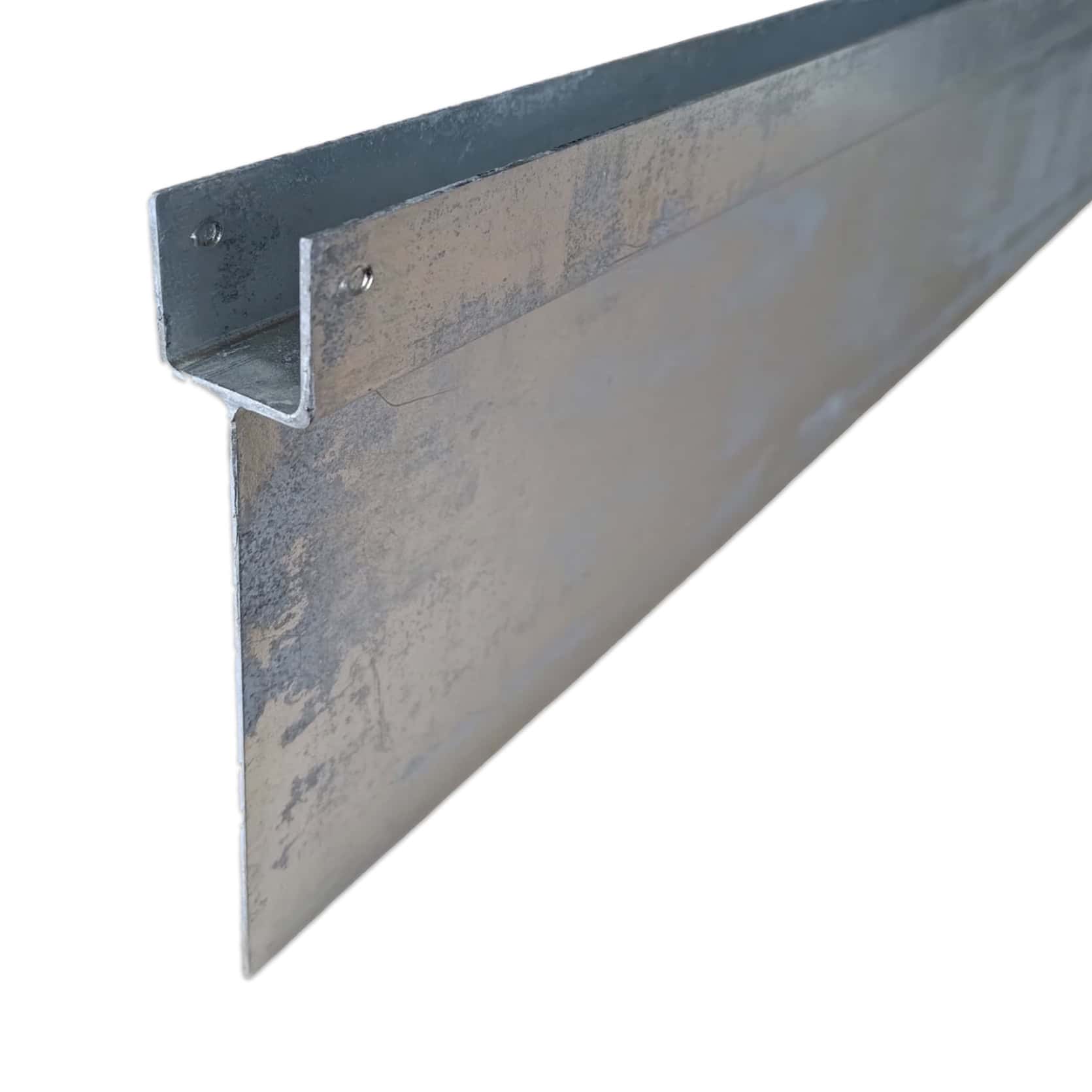 Et nærbillede af en metallisk Z-formet inddækning lavet af varmgalvaniseret stål med en lodret forlængelse, der bruges i bygningskonstruktioner til vejrbeskyttelse og beskyttelse af tagkanter eller samlinger. Metaloverfladen er let struktureret og ser galvaniseret ud.