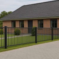 Et moderne murstenshus med mørkt tegltag, vinduer med sorte rammer og en Balusterhegn P-20 i stål foran. I haven er der grønt græs og små buske langs en pæn gangsti.