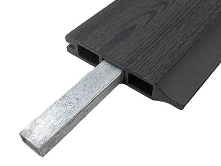 Nærbillede af et hult, mørkt kompositbræt med en Forstærkningsprofil til 25 mm kompositbrædder - varmgalvaniseret stål 15x28 mm delvist indsat i en af dets rektangulære indre kanaler.