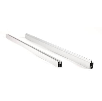 To sølvfarvede aluminiumskanaler med riller, der ligger parallelt på en hvid baggrund.