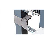 Nærbillede af en hængselbeslag af metal, der er fastgjort til en firkantet metalstolpe med bolte og skruer, sandsynligvis en del af en port- eller hegnmekanisme.