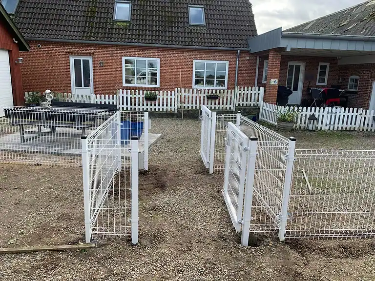 Hvide låger i 3D-panelhegnet ved huset