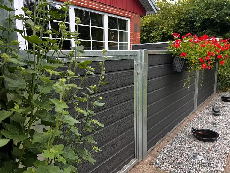 Komposithegn med varmgalvaniserede stolper langs et grusbed
